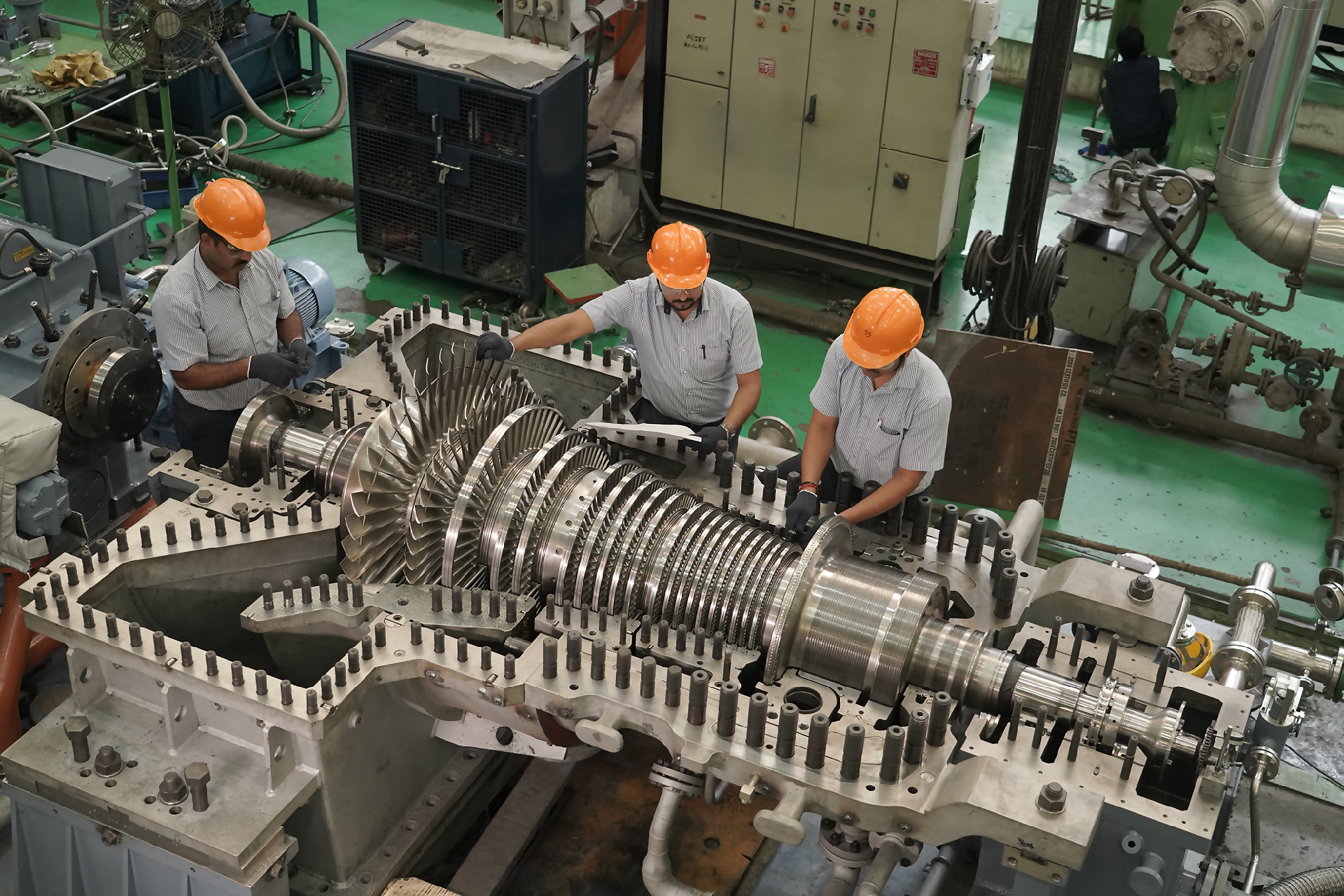 Technicians assembling an industrial gas turbine on the factory floor